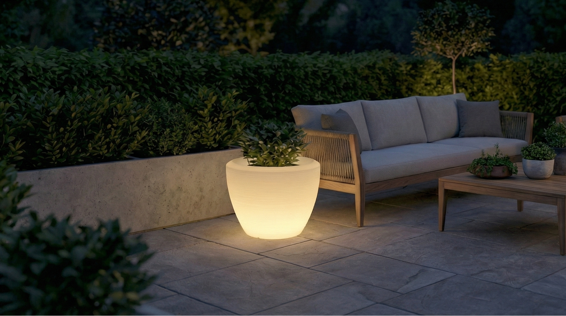 Outdoor patio with furniture and a glowing light feature at night.